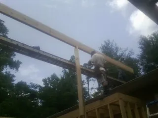 Carpenter setting a ridge beam over a new addition frame — Ice Dam Removal by Roofing Brothers in Vinton