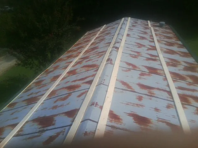 Rusted metal roof panels with new wood purlins before replacement — Storm Damage Roof Repair in Vinton by Roofing Brothers
