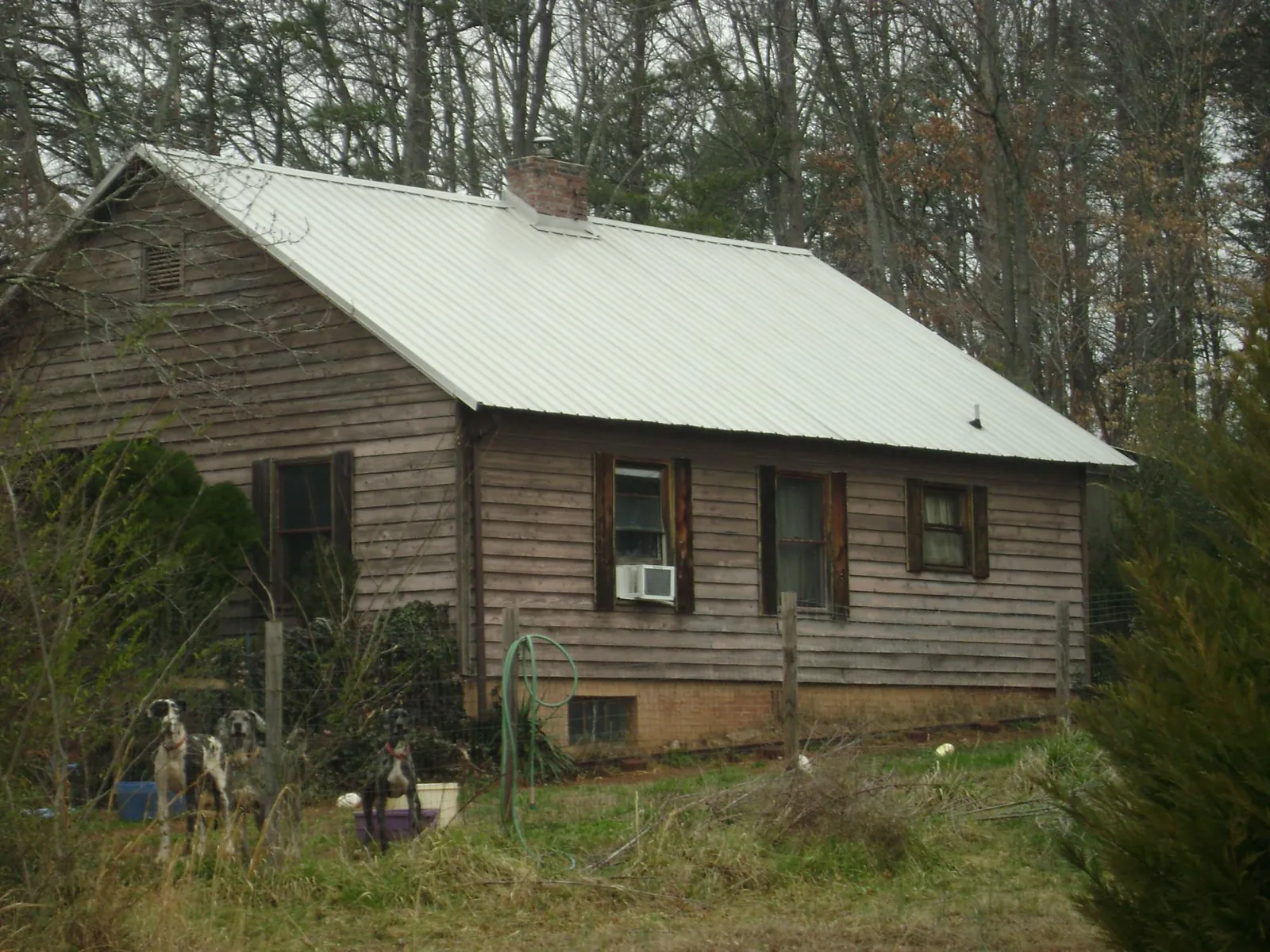 White metal roof on an old wood sided farmhouse, from a Asphalt Shingle Roof Repair job in Vinton